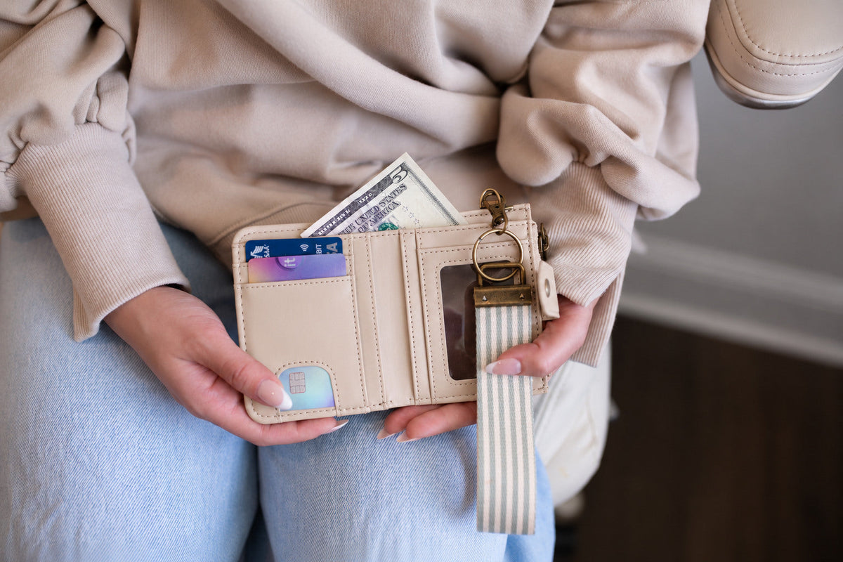 Beige bifold wallet opened to show ID window, card slots and cash pocket